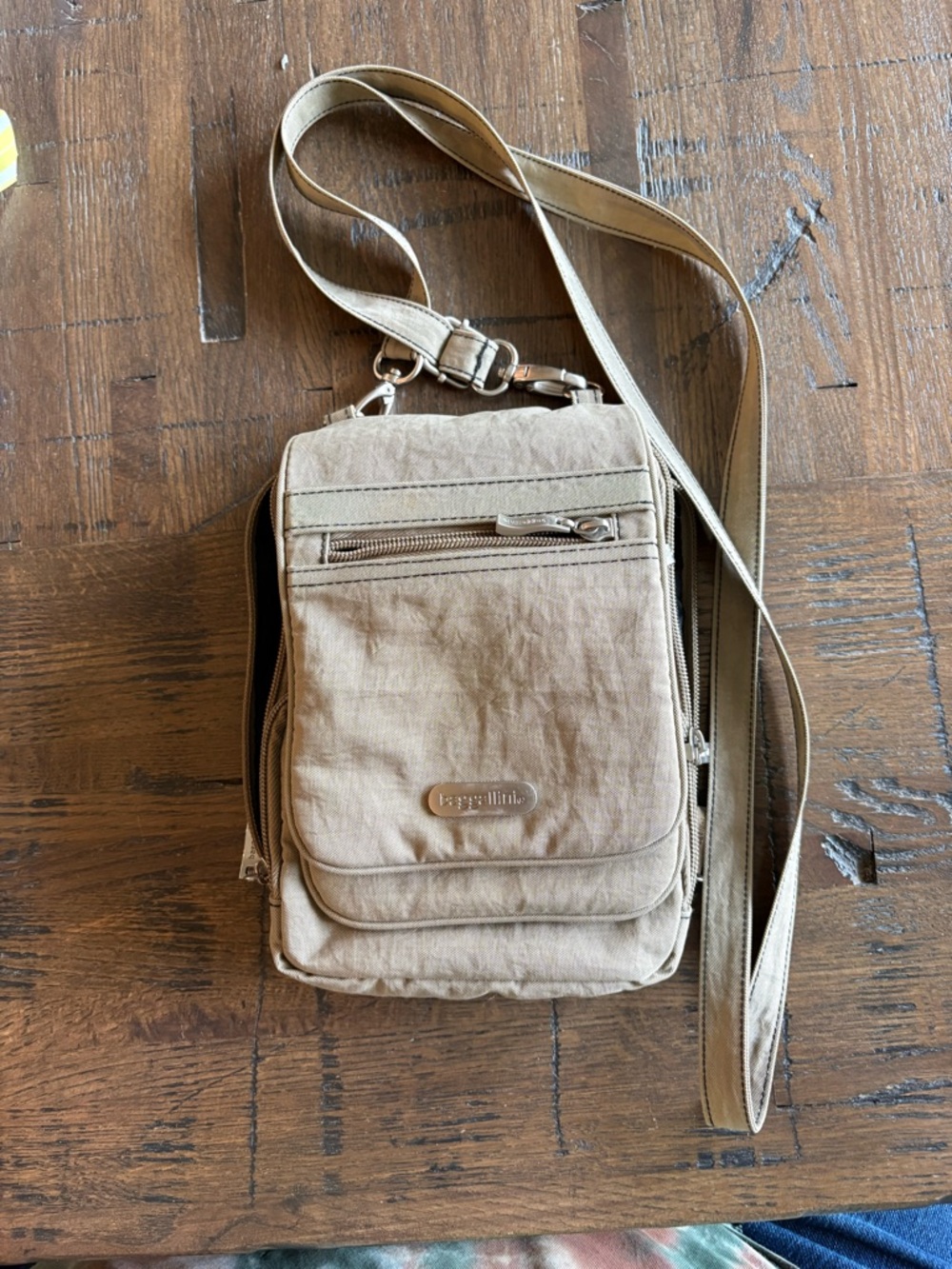 Baggallini tan crossbody messenger bag with adjustable strap that expands to 58”